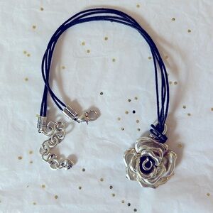 A lovely silver flower necklace with tiny heart accents.